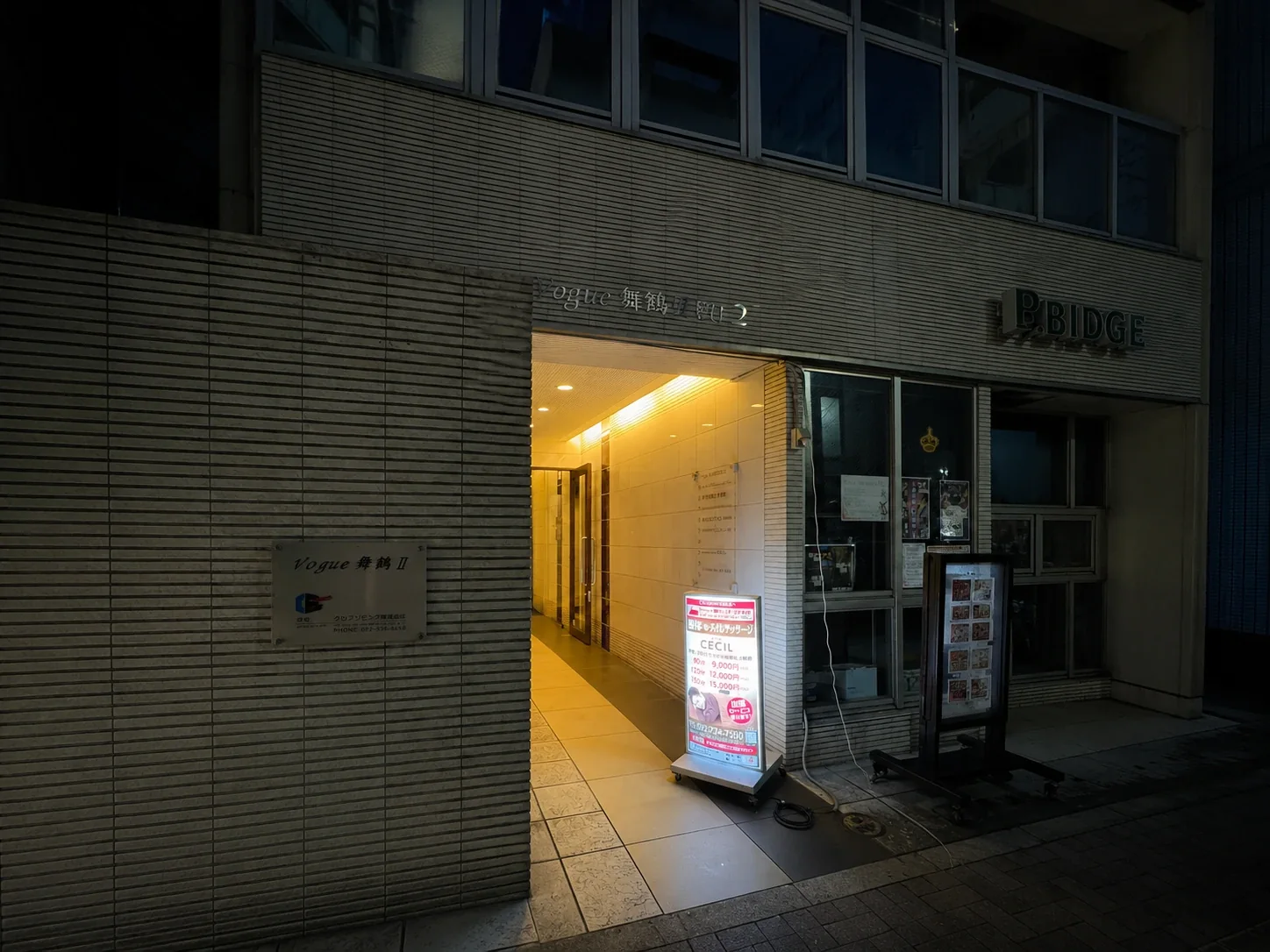 夜のVogue舞鶴Ⅱの建物外観とCECILの案内看板