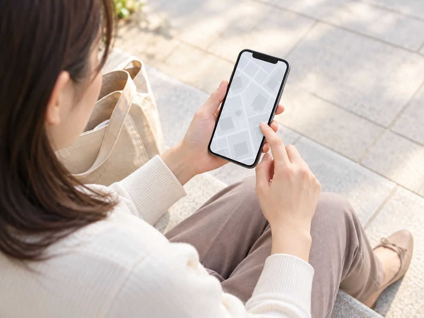 来店前にスマートフォンで場所を確認する女性のお客様のイメージ