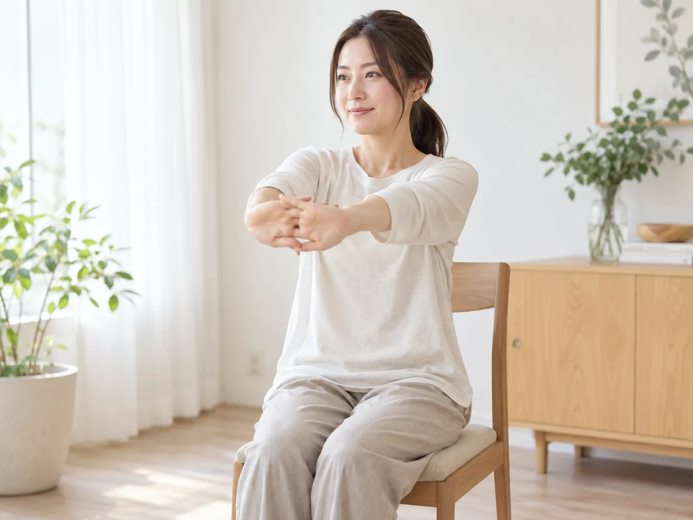 椅子に座って無理なく腕を前へ伸ばす女性のイメージ
