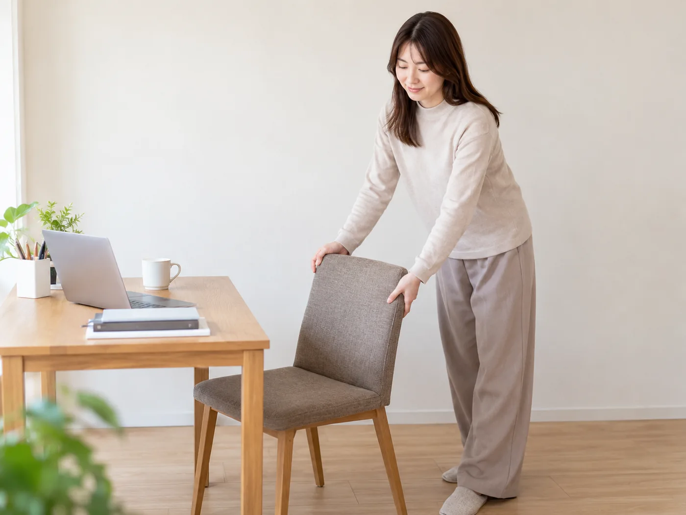 自宅の仕事机を片付けて施術の場所を用意する女性のイメージ