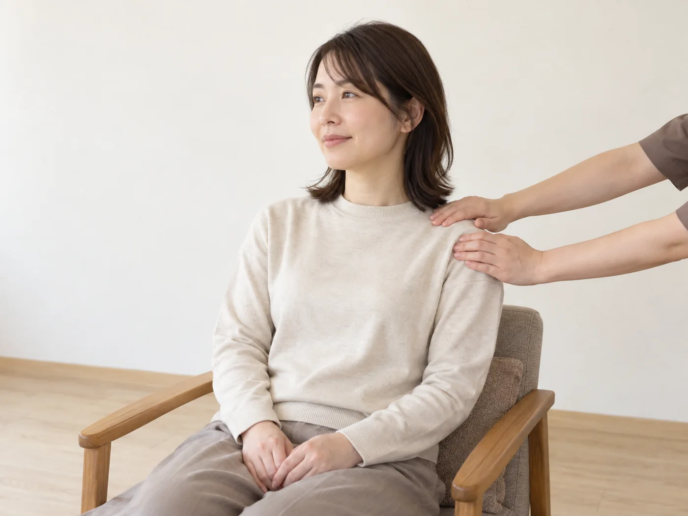 着衣の女性の肩まわりを穏やかにケアする様子のイメージ